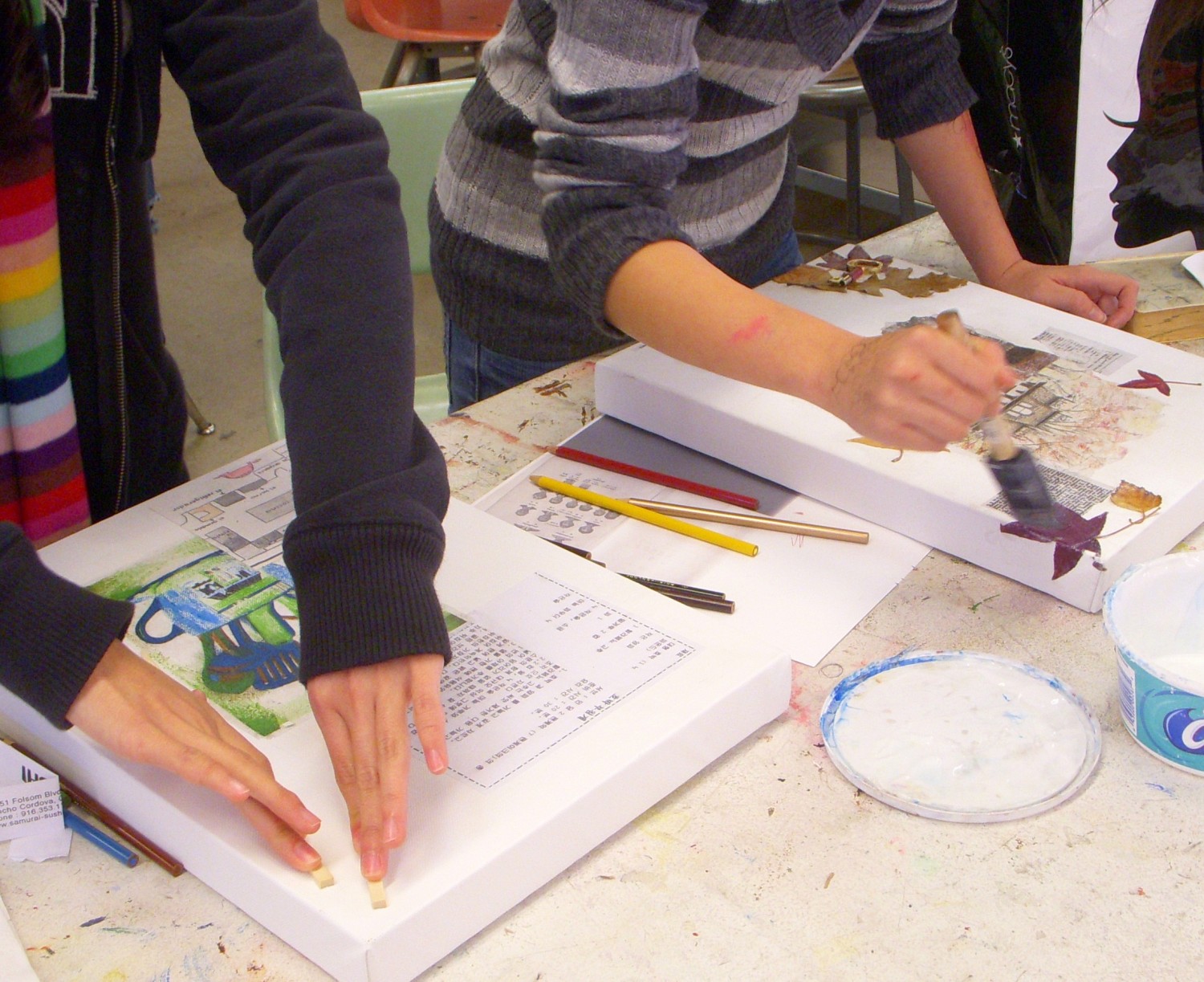 students in a high school art class working on mixed media artworks